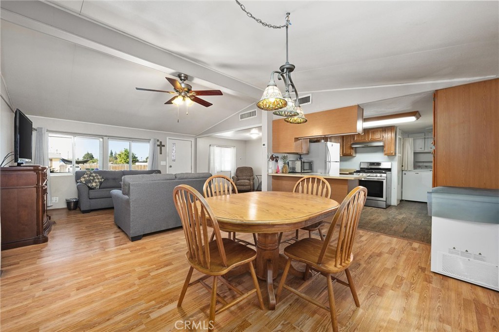 4730 Coronado Street West Bakersfield, CA 93314 - Photo 9 of 29 a dining room with stainless steel appliances kitchen island granite countertop a table chairs and a refrigerator