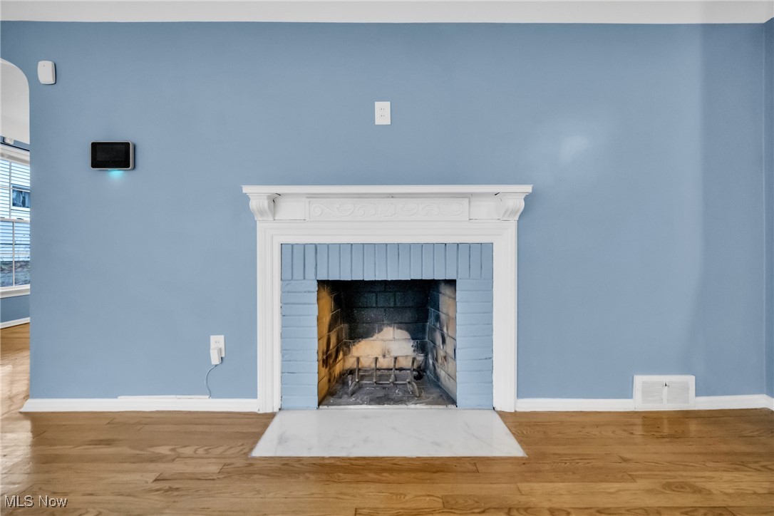 1605 Laclede Road Cleveland, OH 44121 - Photo 27 of 40 Interior details with wood finished floors, baseboards, a brick fireplace, and visible vents