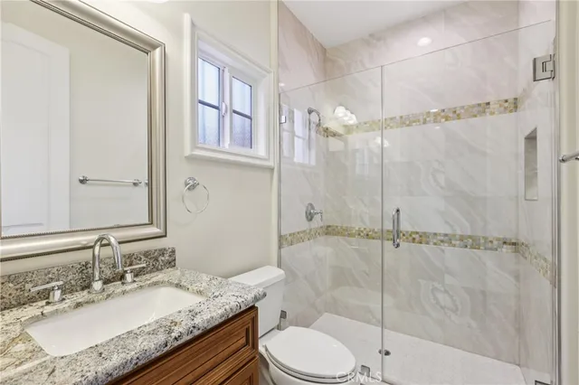 a bathroom with a granite countertop sink toilet and shower