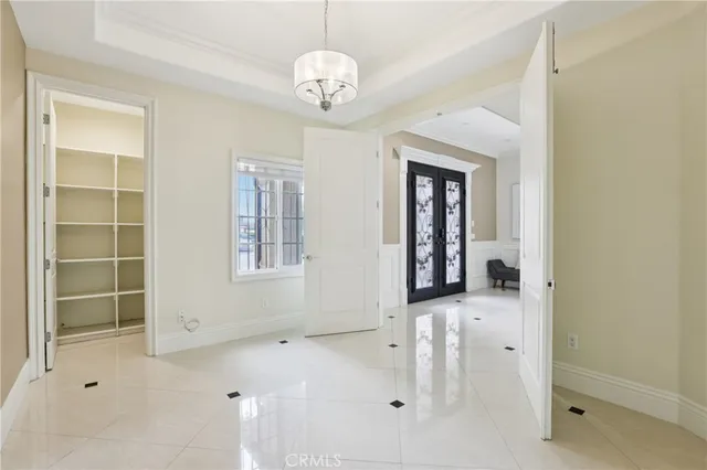 a view of a hallway with windows and chandelier