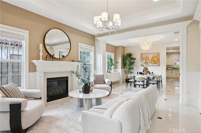 a living room with furniture a fireplace and a chandelier