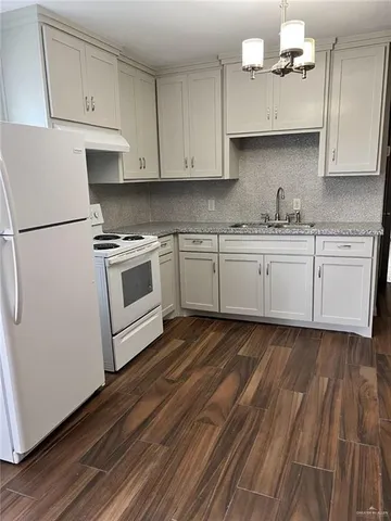 a kitchen with granite countertop white cabinets and white appliances