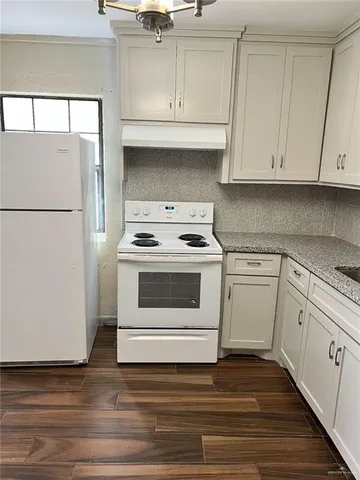 a kitchen with white cabinets and white appliances