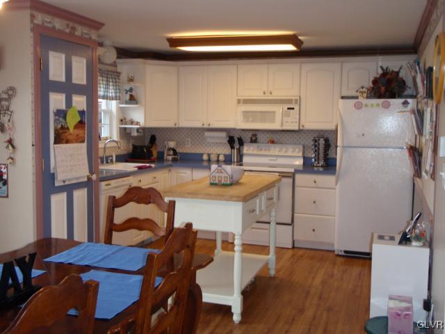 1049 Deemer Road Bath, PA 18014 - Photo 3 of 13 a kitchen with a refrigerator a stove a sink dishwasher and white cabinets with wooden floor