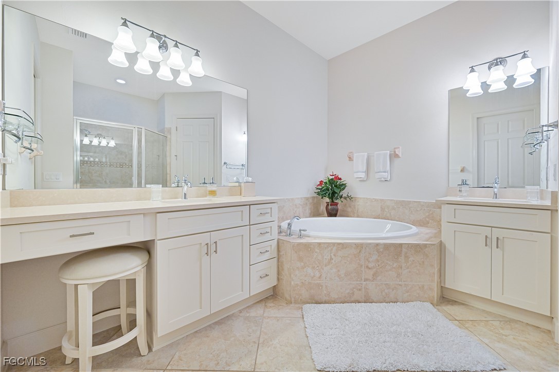 10251 Glastonbury Circle, Unit 201 Fort Myers, FL 33913 - Photo 12 of 45 a spacious bathroom with a sink a large mirror and a shower