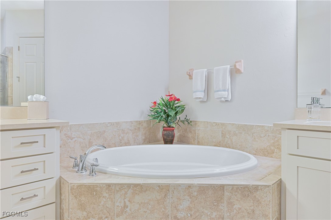 10251 Glastonbury Circle, Unit 201 Fort Myers, FL 33913 - Photo 34 of 45 a bathroom with a bathtub sink and mirror