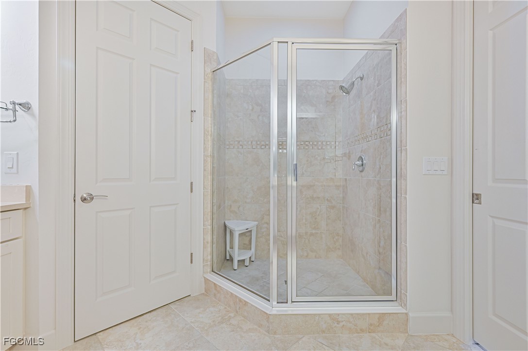 10251 Glastonbury Circle, Unit 201 Fort Myers, FL 33913 - Photo 35 of 45 a bathroom with a glass shower door