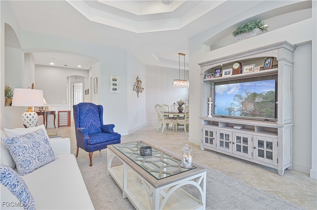 10251 Glastonbury Circle, Unit 201 Fort Myers, FL 33913 - Photo 5 of 45 a living room with furniture a rug and a painting on the wall