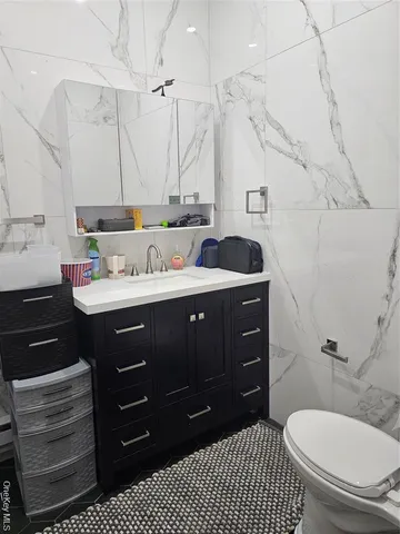 a bathroom with a sink vanity granite and toilet