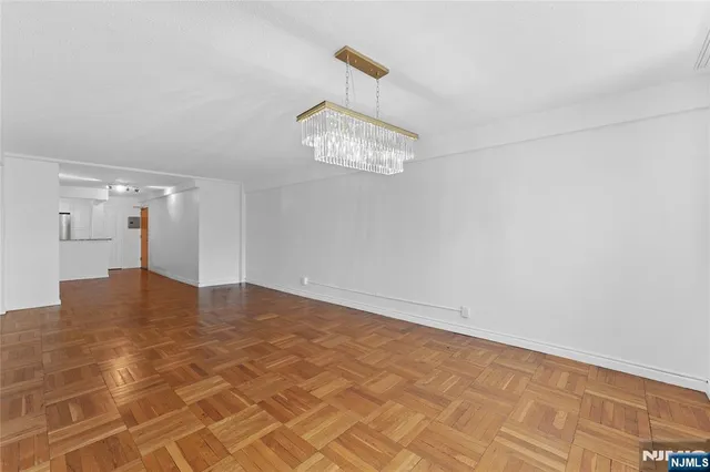 a view of a room with a chandelier fan and windows