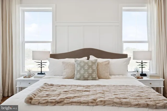 a large bed sitting in a bedroom next to a window