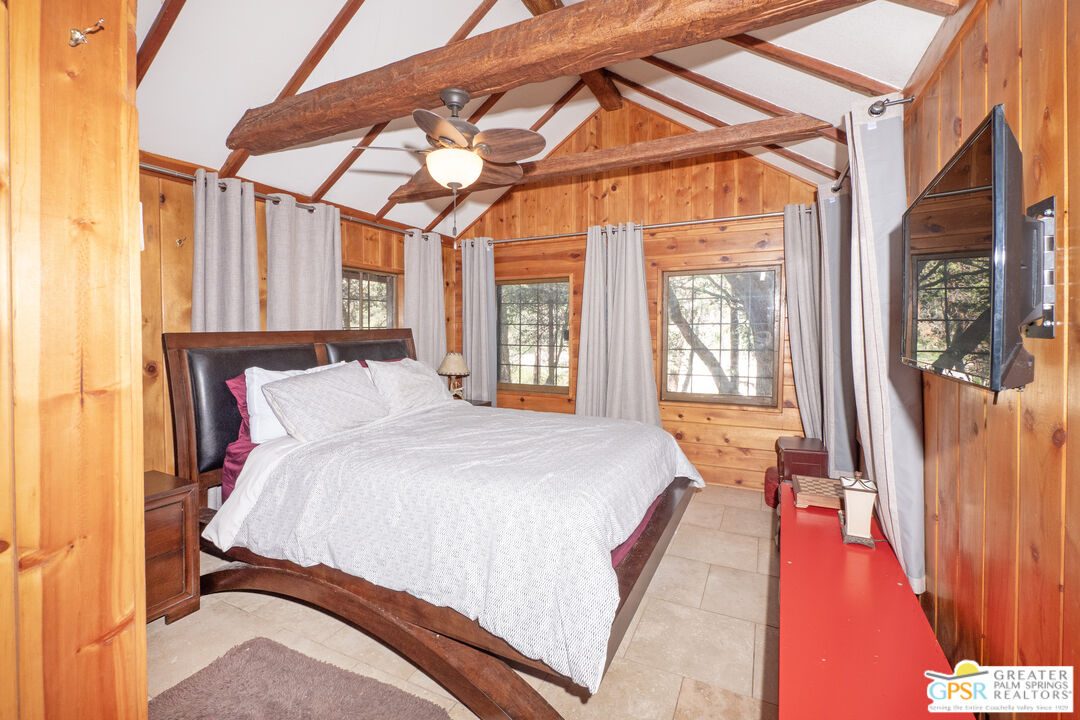 76 7 Oaks Road Angelus Oaks, CA 92305 - Photo 15 of 35 a spacious bedroom with a large bed and a chandelier