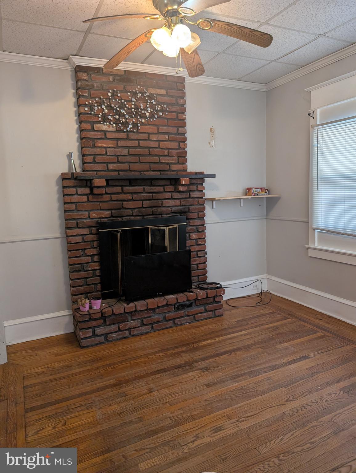 78 Blackwood Road Clementon, NJ 08021 - Photo 3 of 6 a view of an empty room with wooden floor fireplace and a window