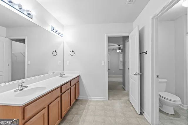 a spacious bathroom with a granite countertop sink a toilet and shower