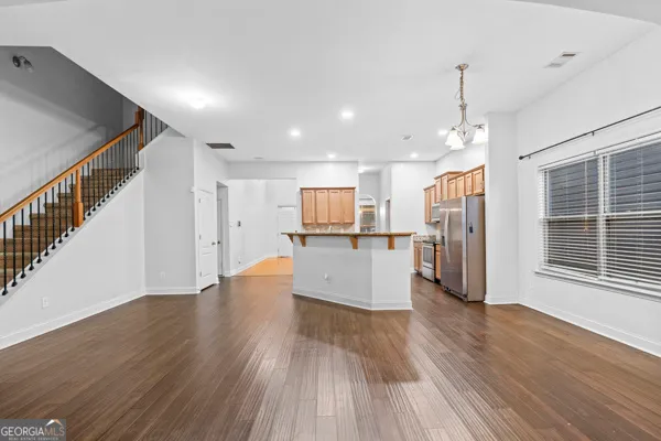 a view of kitchen with refrigerator and wooden floor