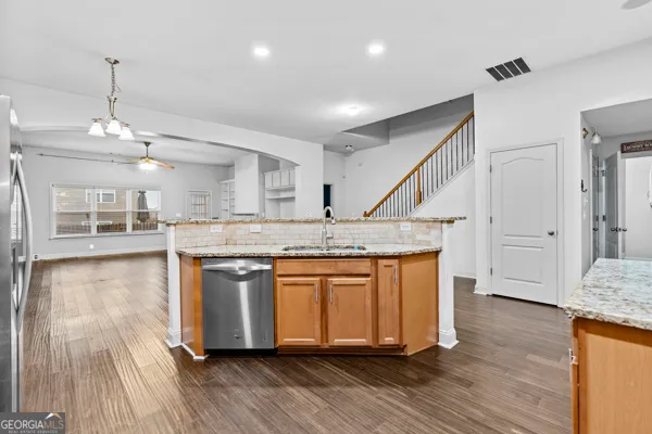 a kitchen with stainless steel appliances granite countertop wooden floors and granite counter tops
