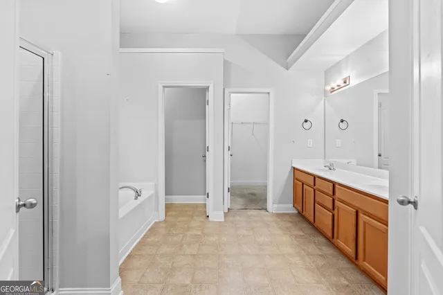 a spacious bathroom with a mirror and a sink