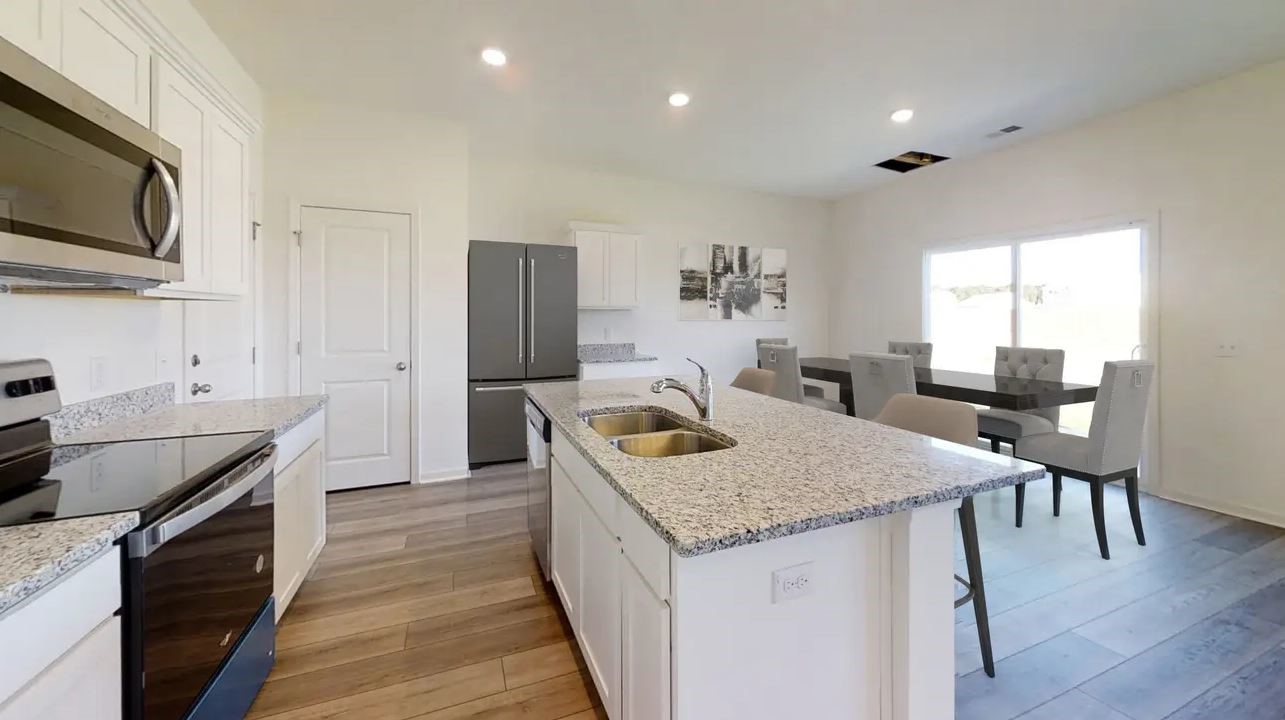 18216 Papuan Cove Elgin, TX 78621 - Photo 7 of 11 a kitchen with a stove and a refrigerator