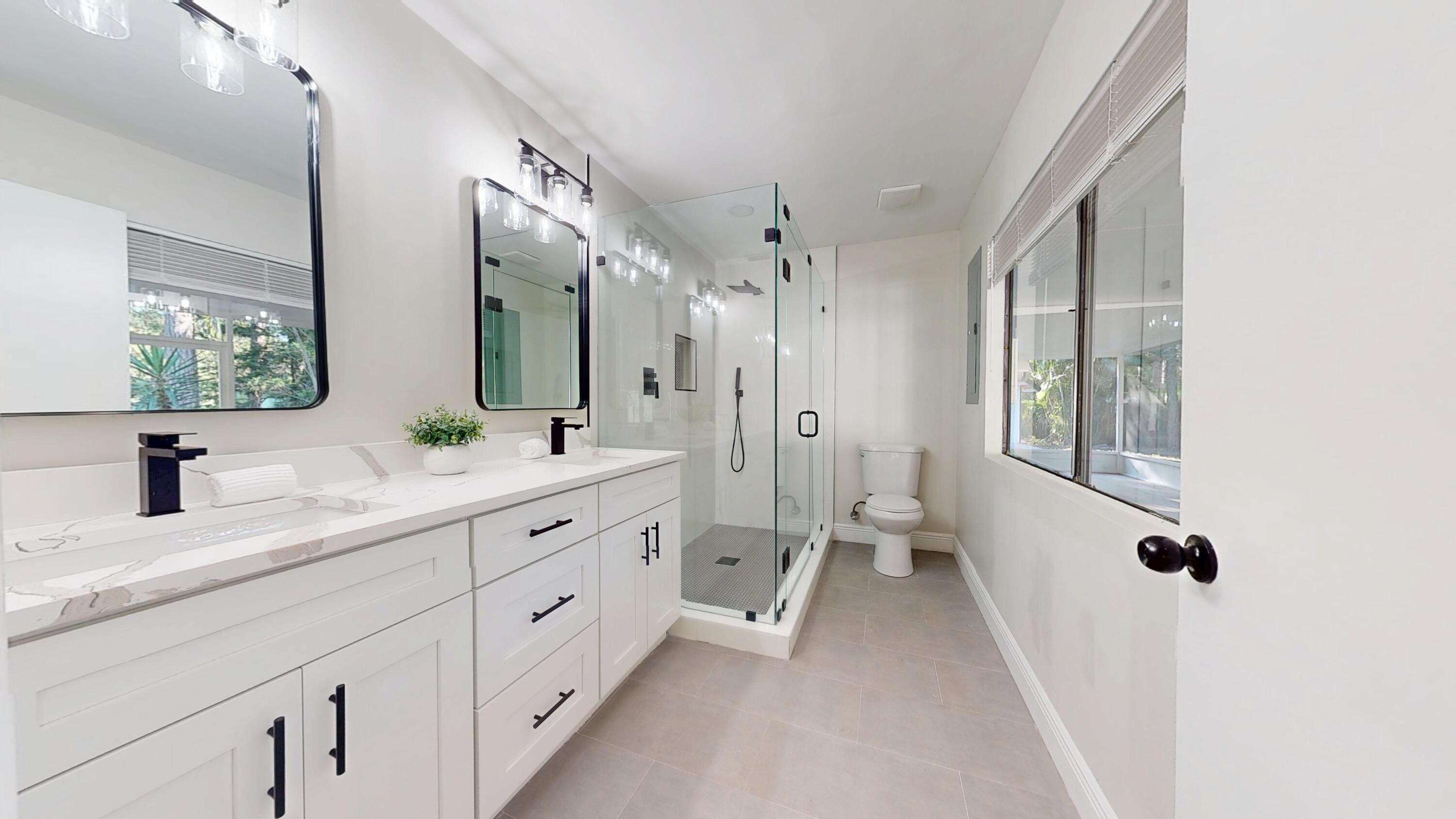 13018 153rd Road North Jupiter, FL 33478 - Photo 19 of 37 a spacious bathroom with a double vanity sink a mirror and a shower