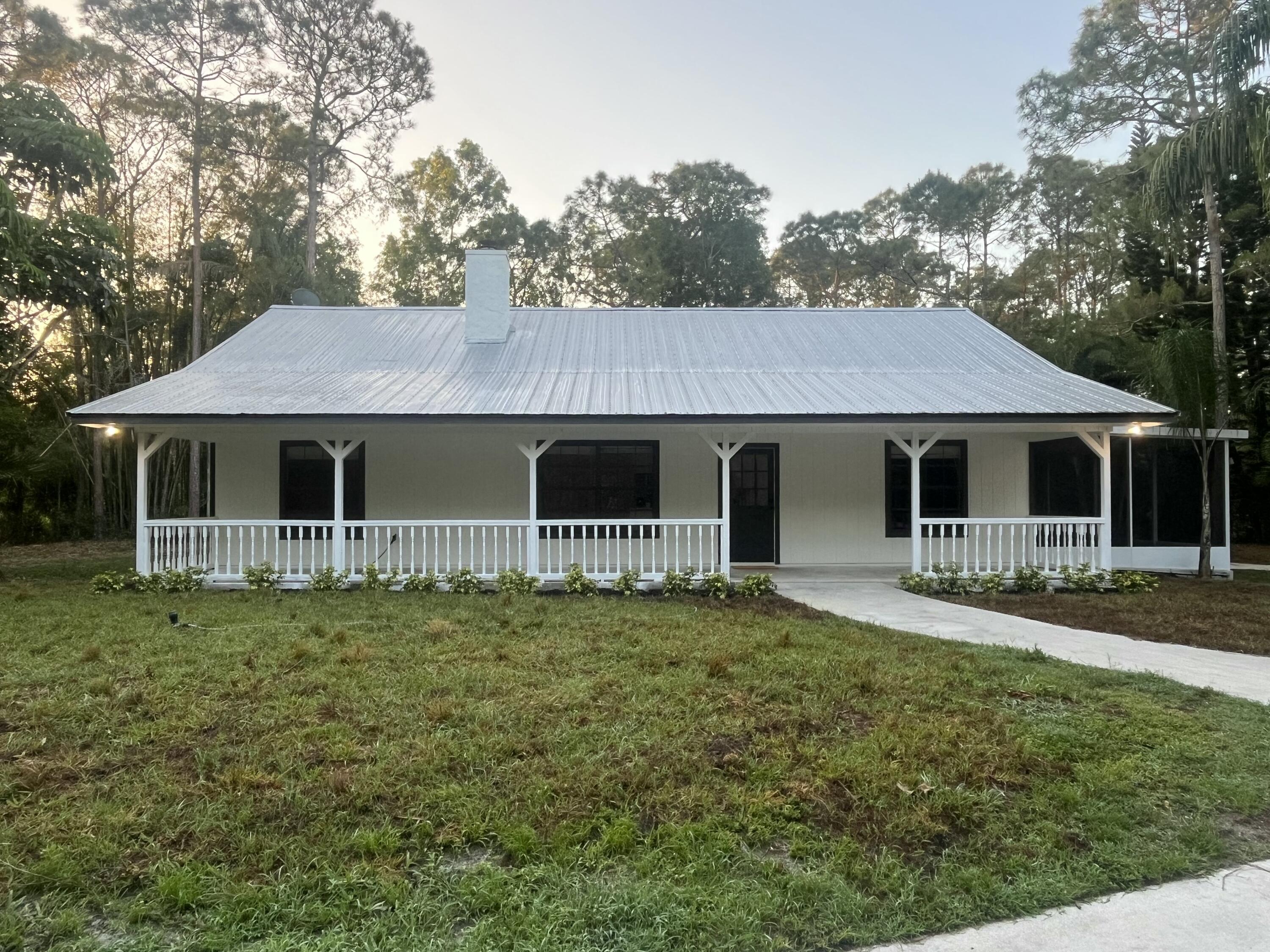 13018 153rd Road North Jupiter, FL 33478 - Photo 2 of 37 a front view of a house with a garden