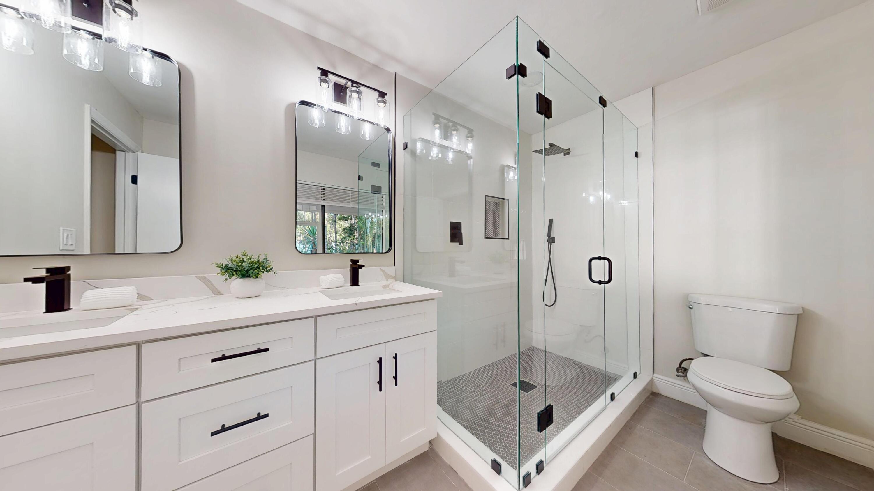 13018 153rd Road North Jupiter, FL 33478 - Photo 21 of 37 a bathroom with a double vanity sink toilet mirror and shower