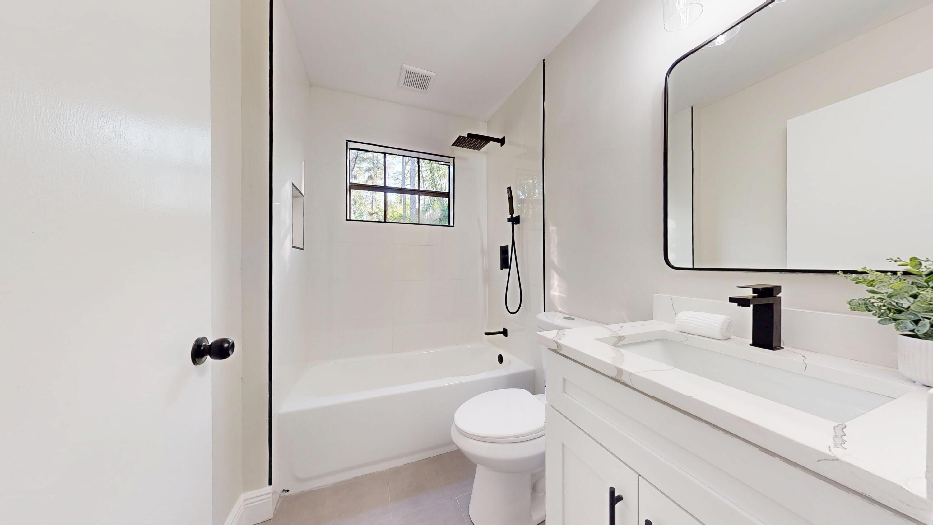 13018 153rd Road North Jupiter, FL 33478 - Photo 23 of 37 a bathroom with a bathtub shower sink vanity and toilet