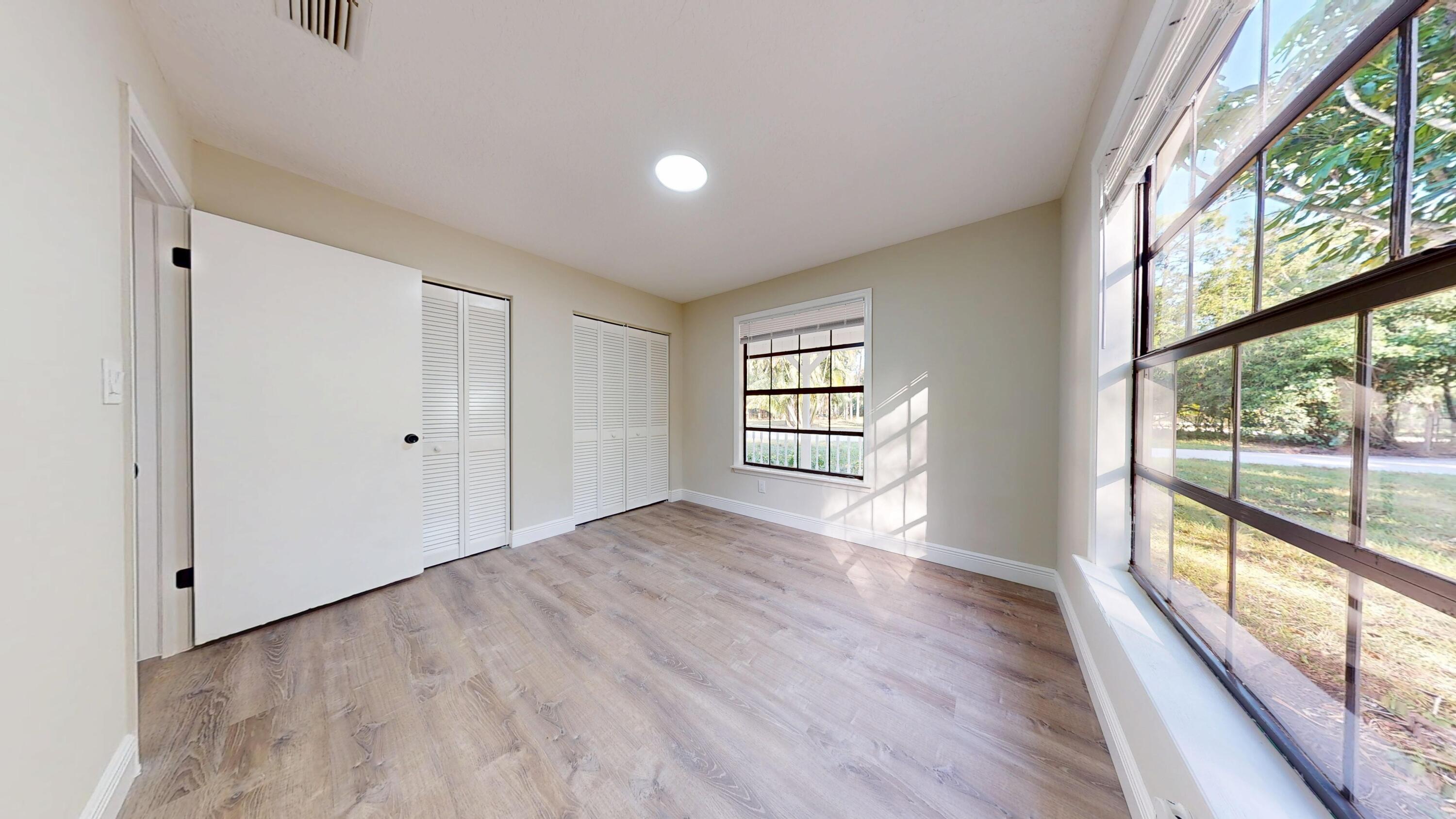 13018 153rd Road North Jupiter, FL 33478 - Photo 25 of 37 a view of an empty room with wooden floor and a window