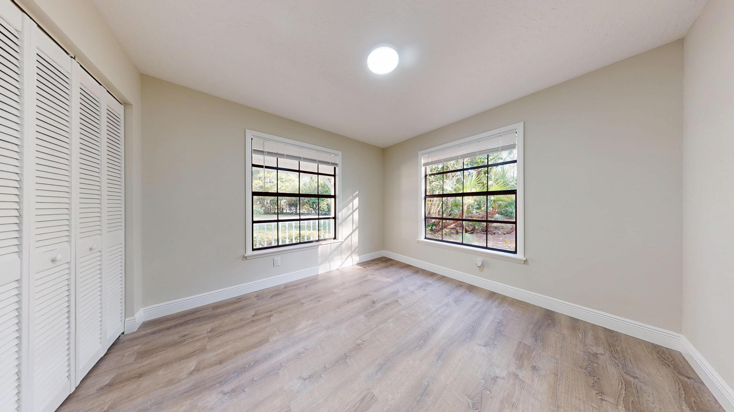 13018 153rd Road North Jupiter, FL 33478 - Photo 26 of 37 an empty room with wooden floor and windows