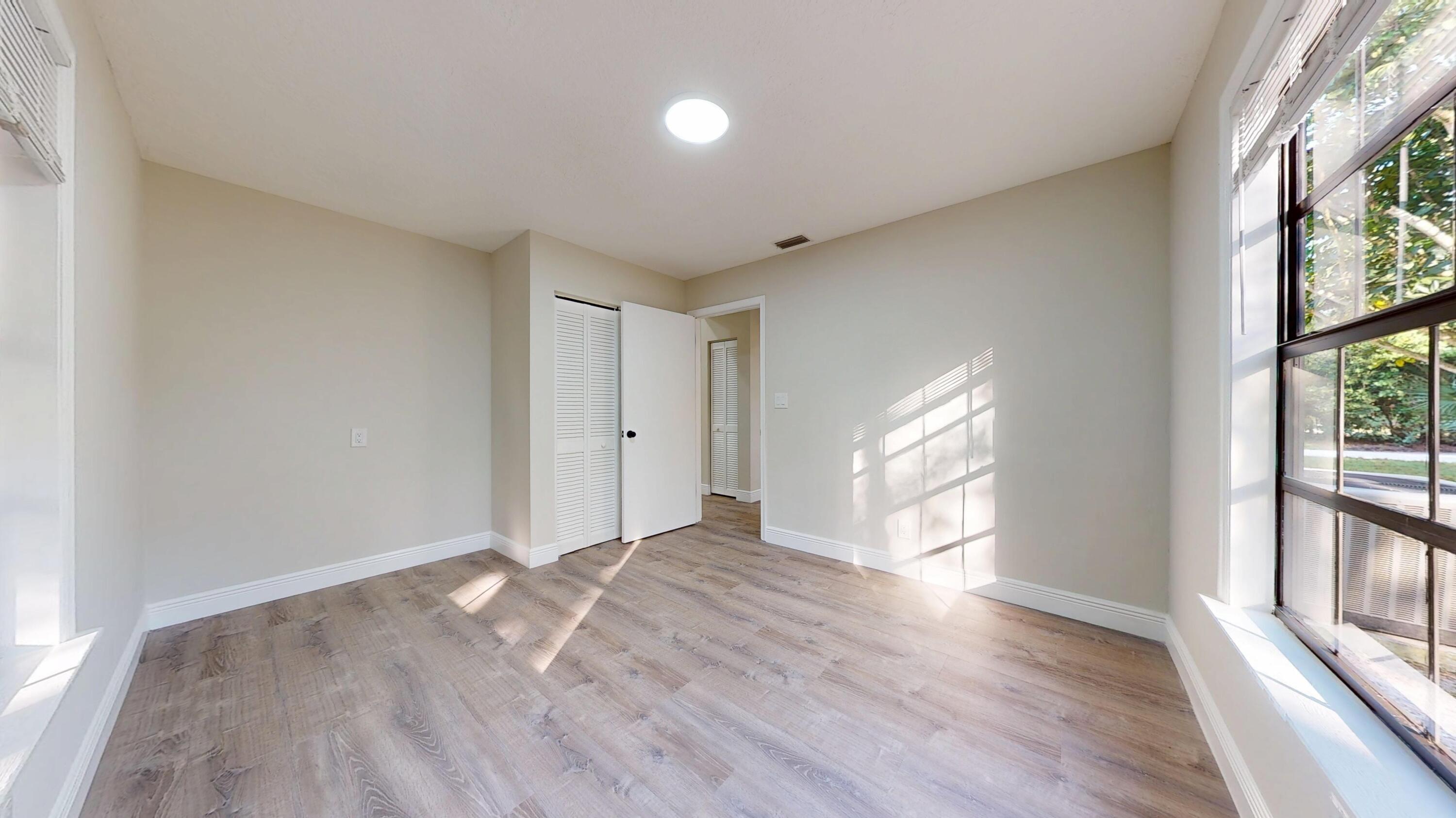 13018 153rd Road North Jupiter, FL 33478 - Photo 28 of 37 a view of an empty room with wooden floor and a window