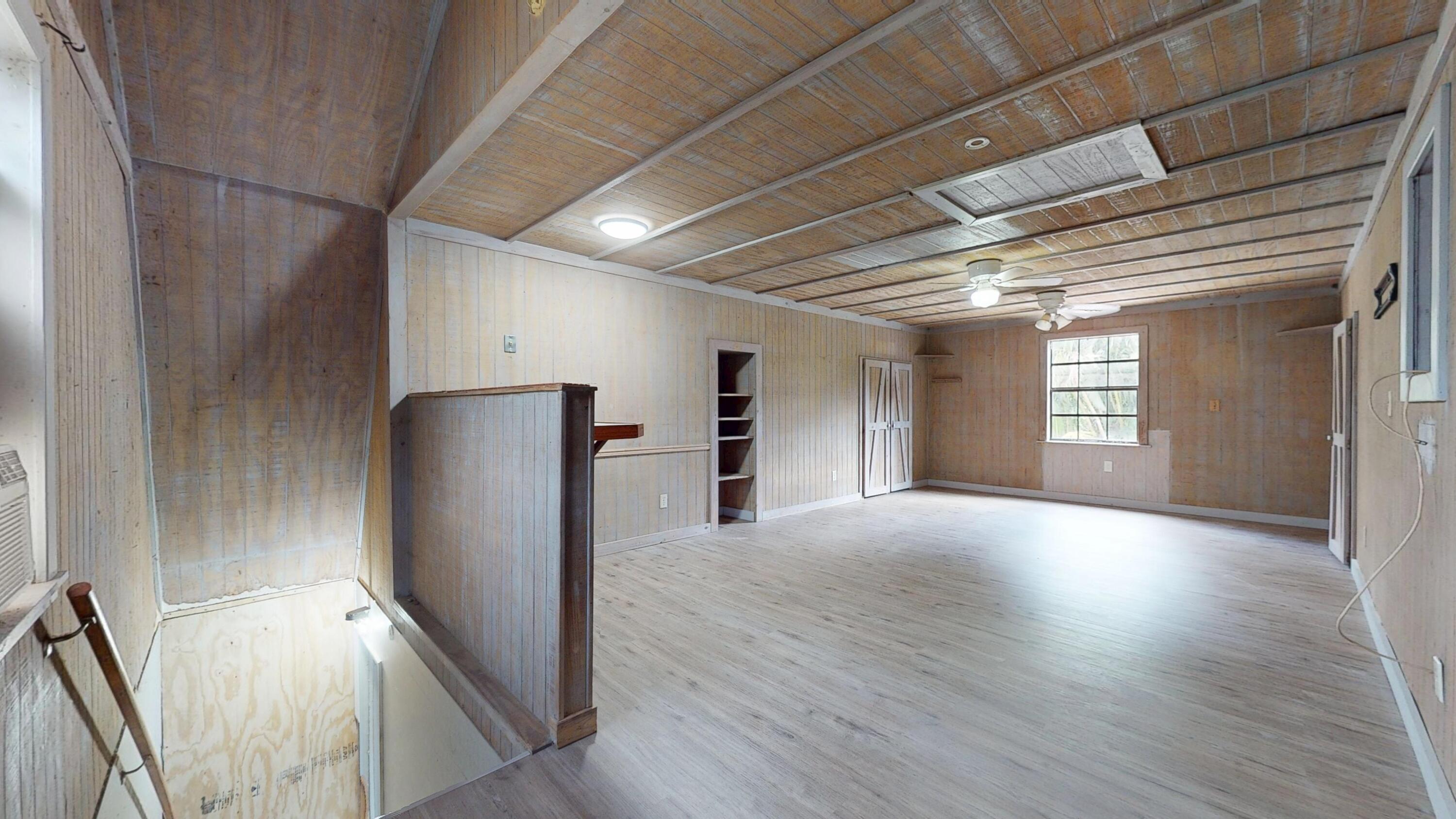 13018 153rd Road North Jupiter, FL 33478 - Photo 34 of 37 a view of an empty room with wooden floor and a refrigerator
