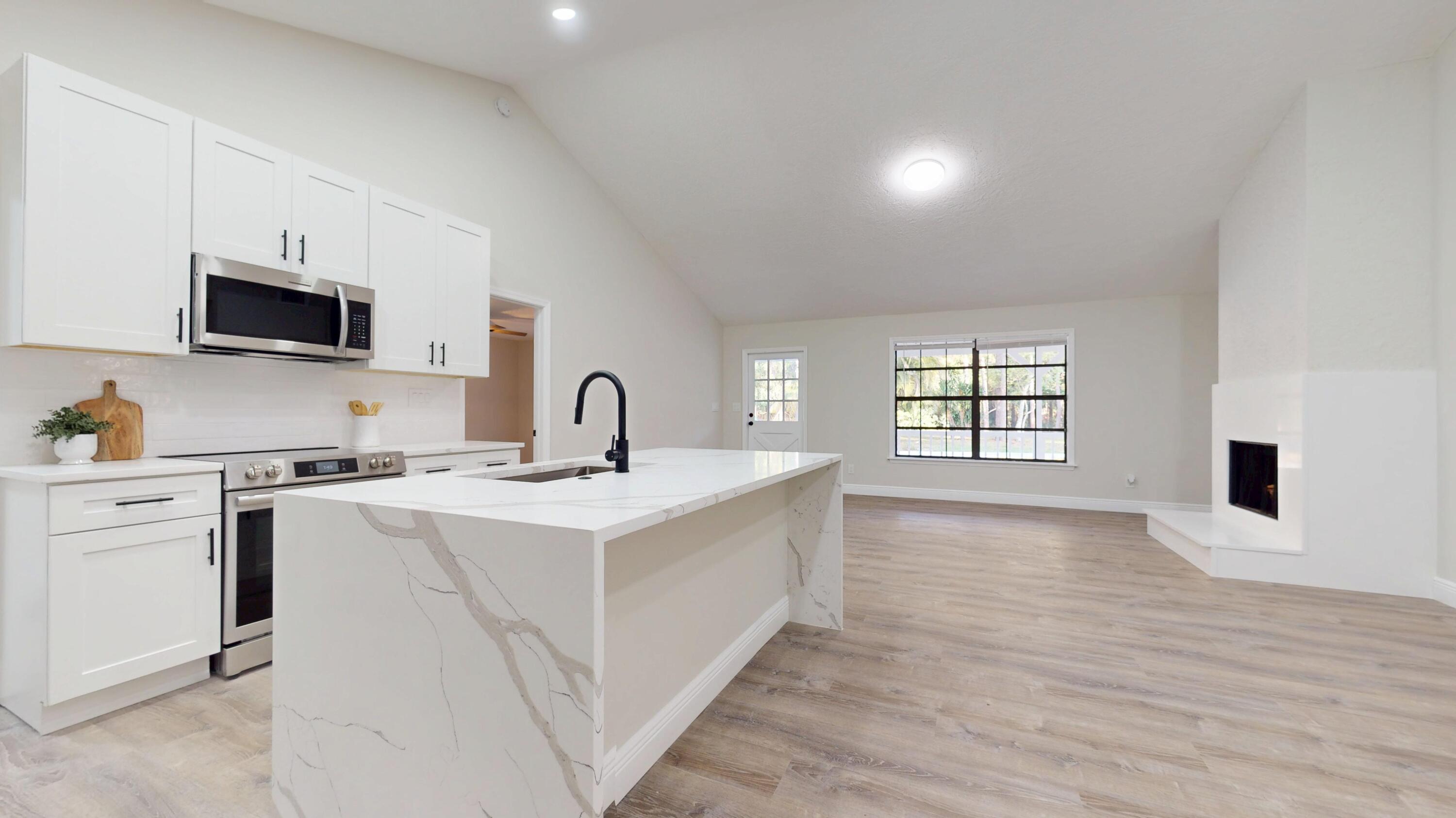 13018 153rd Road North Jupiter, FL 33478 - Photo 6 of 37 a kitchen with a sink stove top oven and microwave