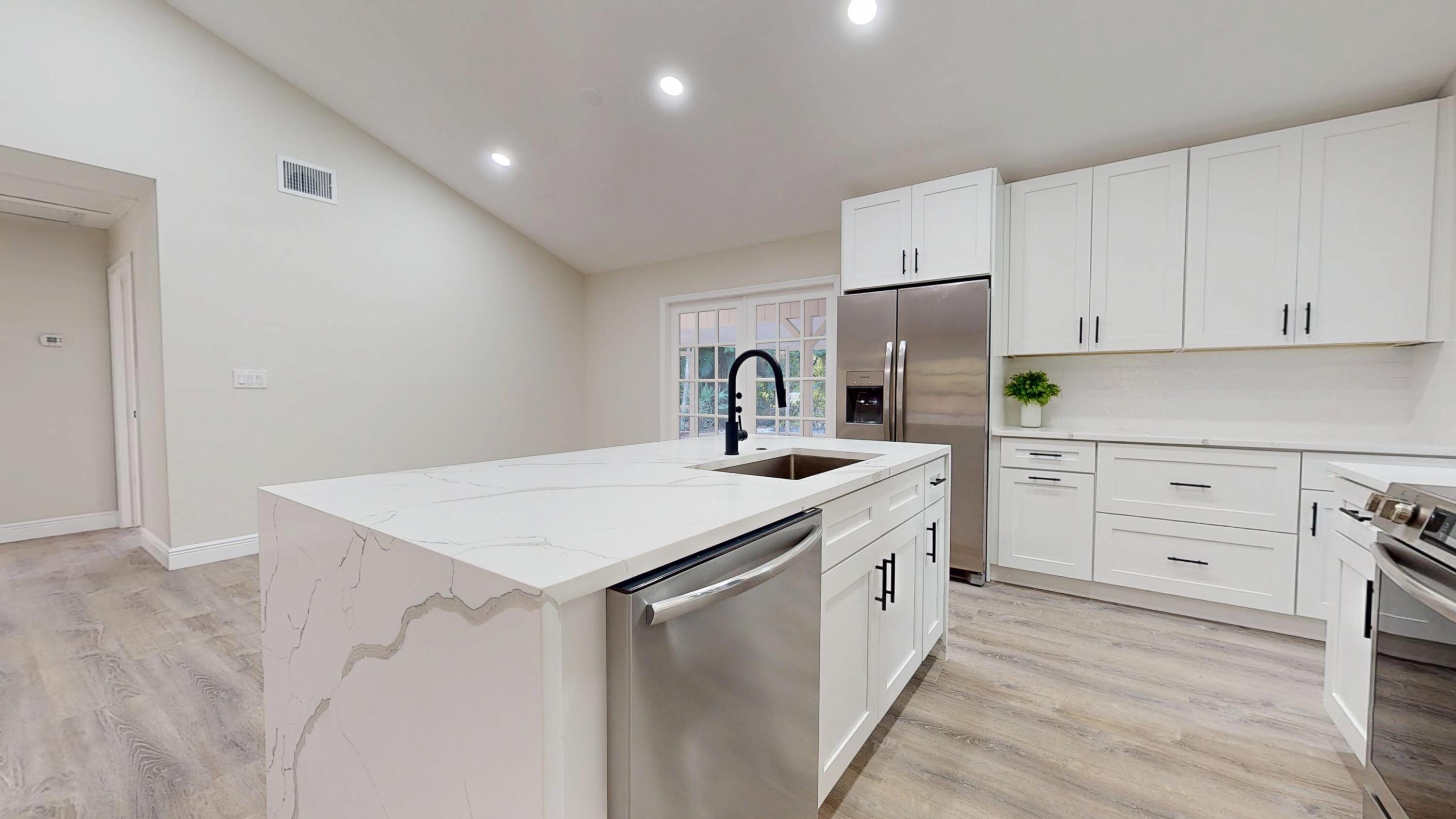 13018 153rd Road North Jupiter, FL 33478 - Photo 9 of 37 a kitchen with granite countertop a sink and cabinets