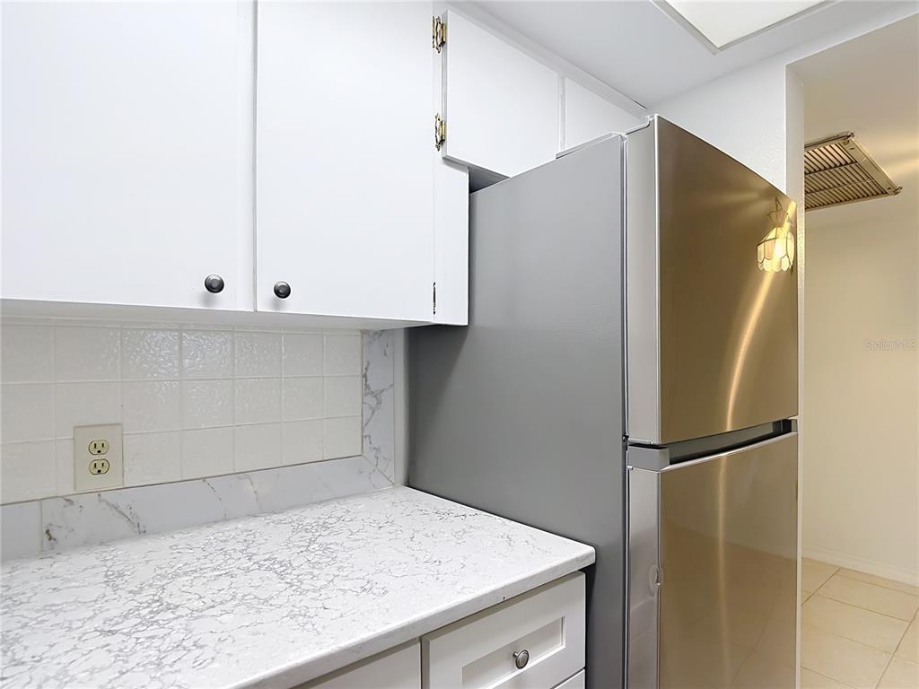 5132 Amulet Drive, Unit 105 New Port Richey, FL 34652 - Photo 17 of 42 a kitchen with a white cabinets and a refrigerator