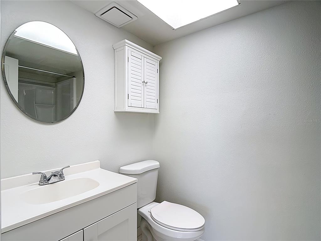 5132 Amulet Drive, Unit 105 New Port Richey, FL 34652 - Photo 4 of 42 a bathroom with a toilet a sink and mirror