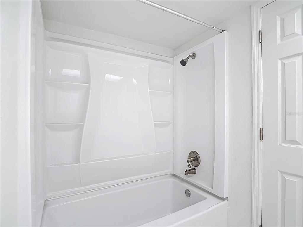 5132 Amulet Drive, Unit 105 New Port Richey, FL 34652 - Photo 5 of 42 a bathroom with a tub and shower