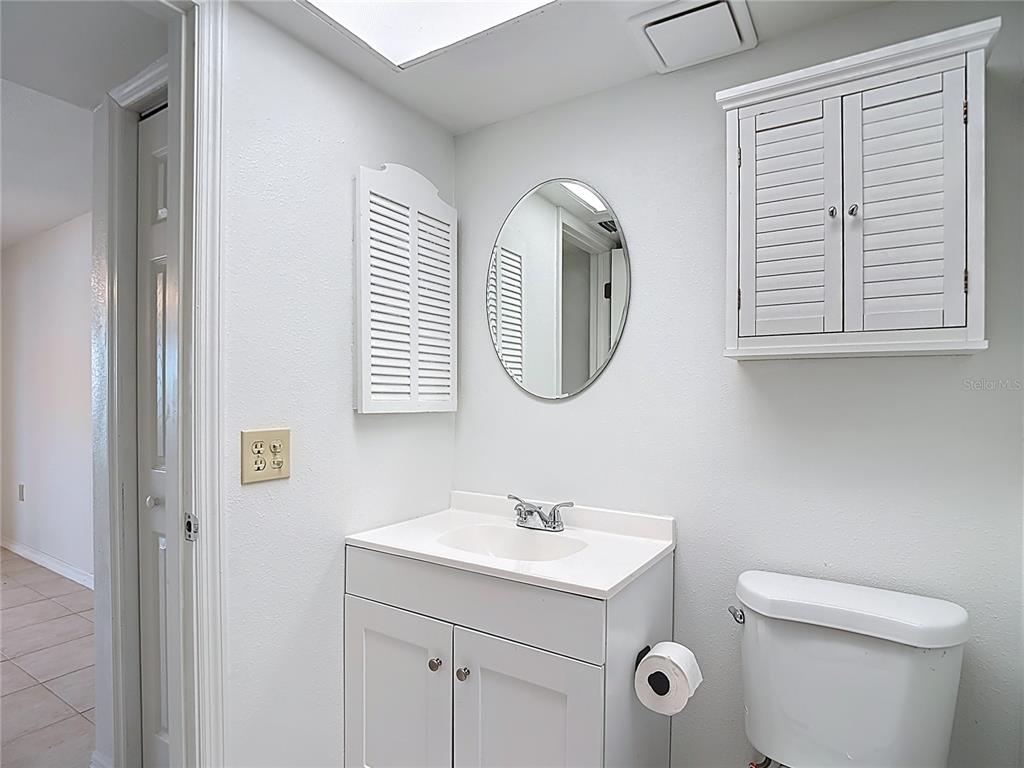 5132 Amulet Drive, Unit 105 New Port Richey, FL 34652 - Photo 6 of 42 a bathroom with a toilet a sink and a mirror