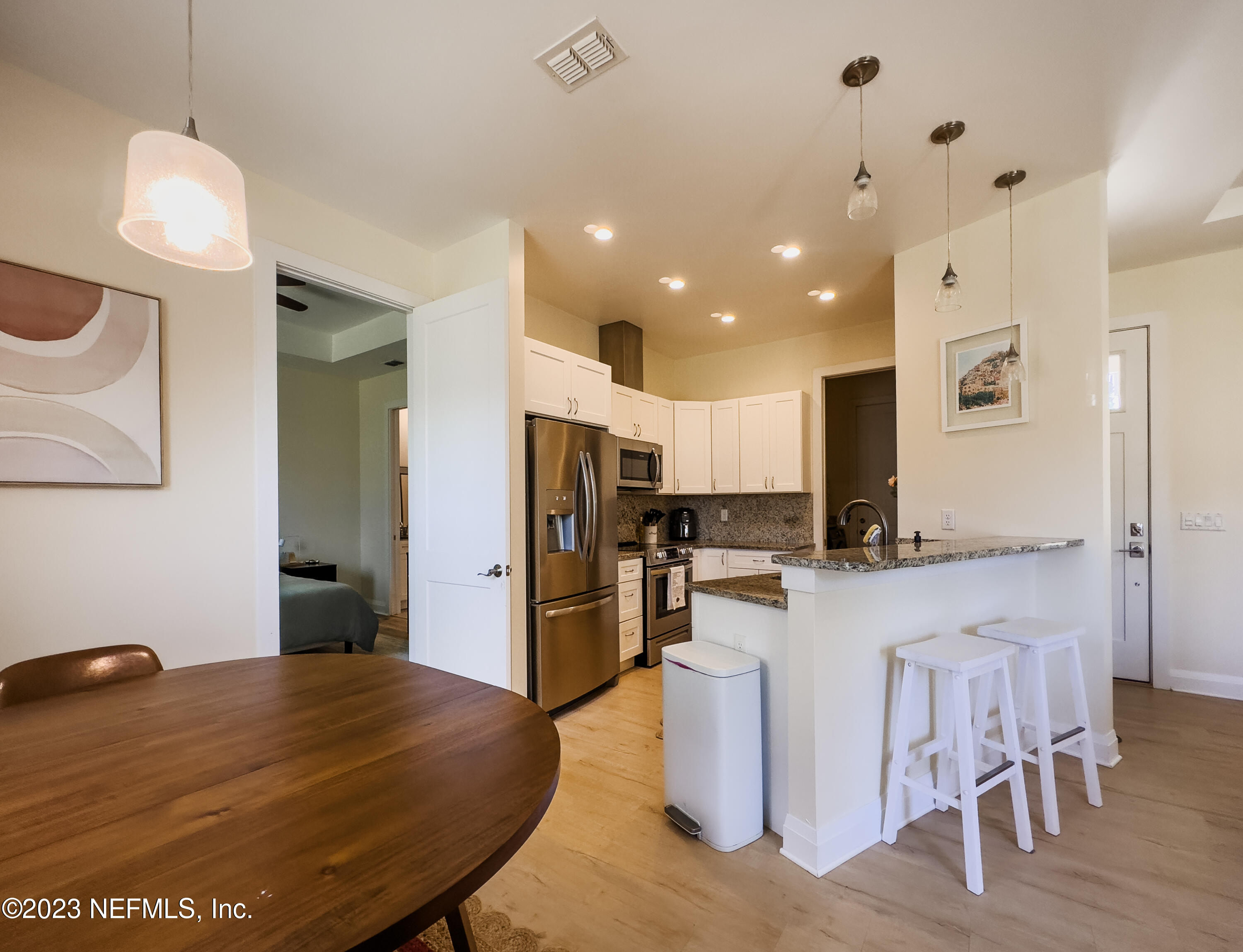 5125 Gracewood Lane St. Augustine, FL 32092 - Photo 7 of 21 a kitchen with stainless steel appliances kitchen island granite countertop a table chairs and a refrigerator