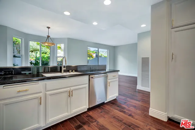 a large white kitchen with sink and window