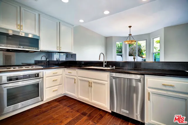 a kitchen with granite countertop white cabinets and white appliances