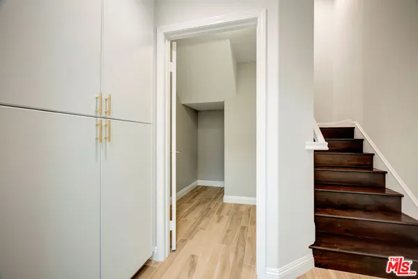a view of a hallway with wooden floor and entryway