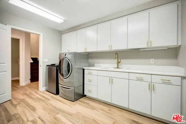 a kitchen with a sink and a washer dryer