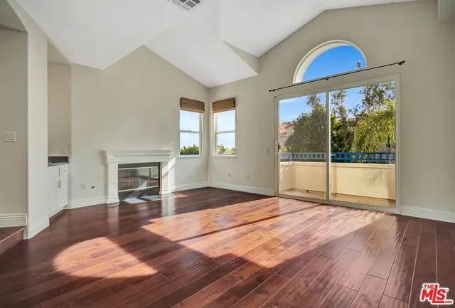 a view of empty room with wooden floor and fireplace