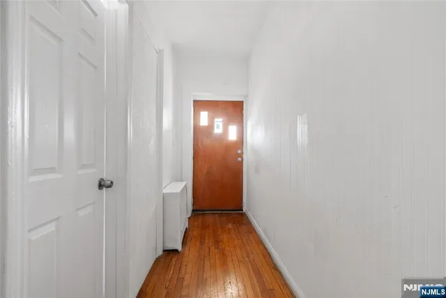 a view of a hallway with wooden floor