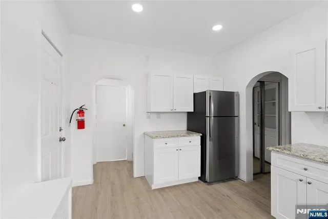 a kitchen with refrigerator a microwave and wooden floor