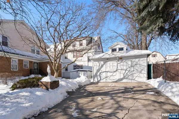 a view of a white house with a yard covered in snow
