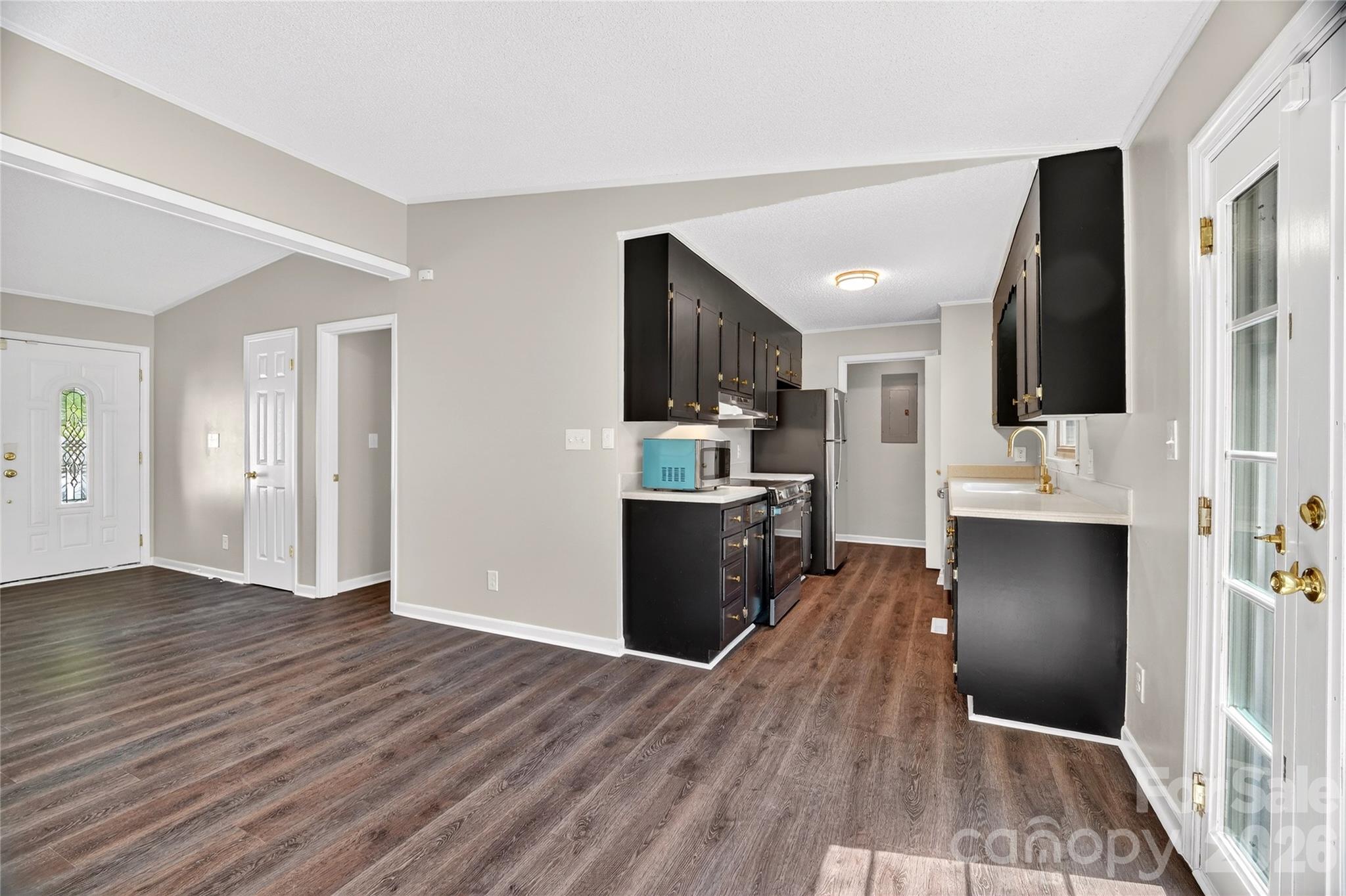 1919 Oak Hollow Road Gastonia, NC 28054 - Photo 11 of 36 a view of a kitchen from the hallway with a sink and wooden floor