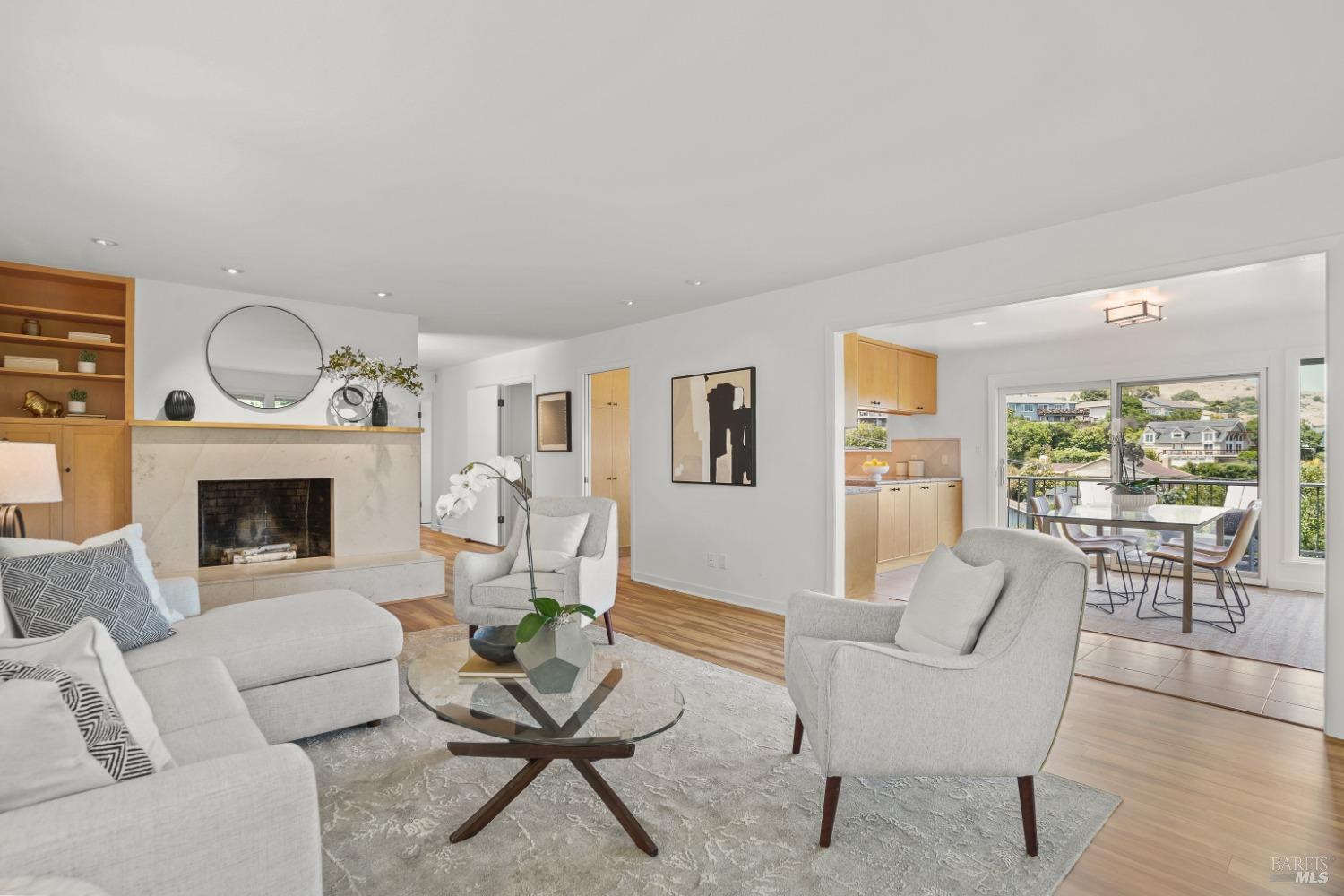 a living room with furniture a fireplace and a large window
