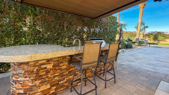 a patio with table and chairs and potted plants
