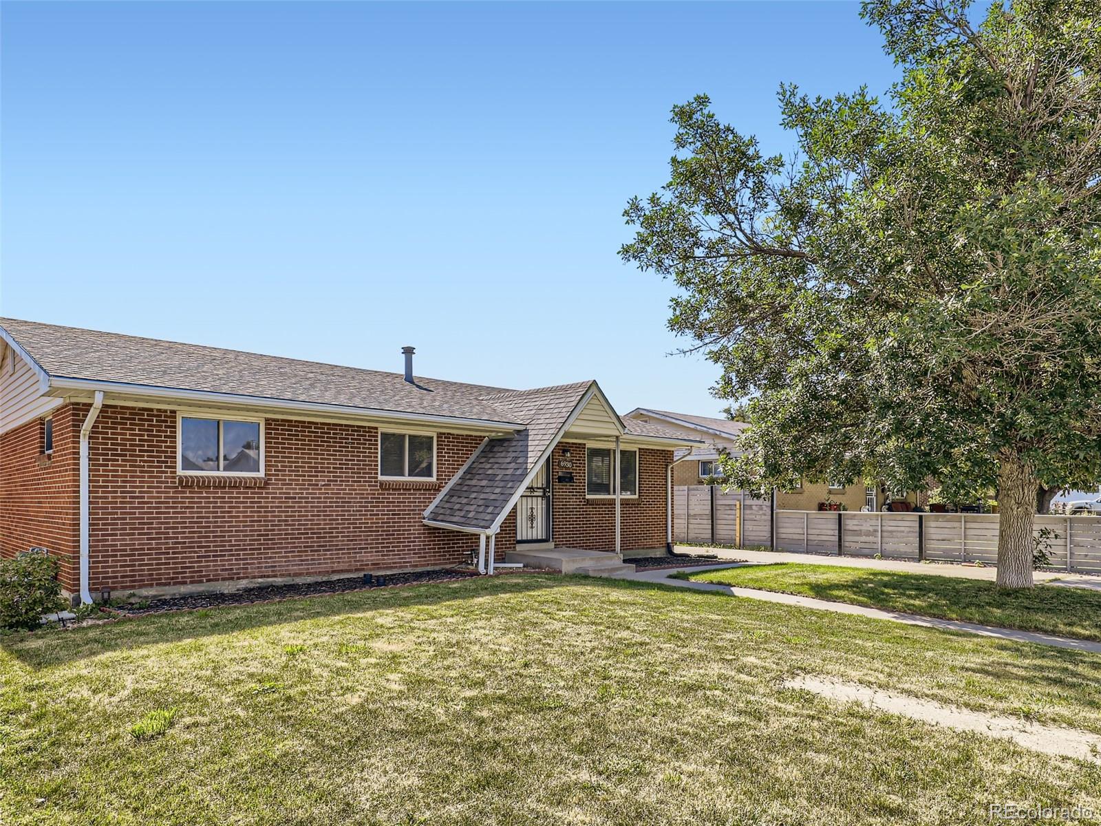 6930 North Locust Street Commerce City, CO 80022 - Photo 17 of 17 a front view of a house with a garden
