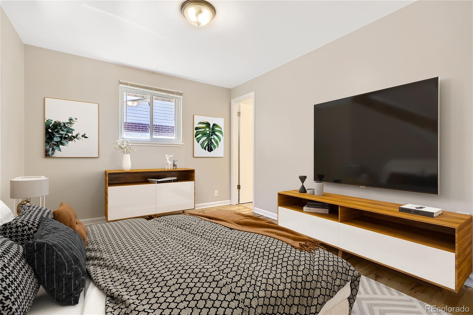 6930 North Locust Street Commerce City, CO 80022 - Photo 5 of 17 a bedroom with a bed and a flat screen tv